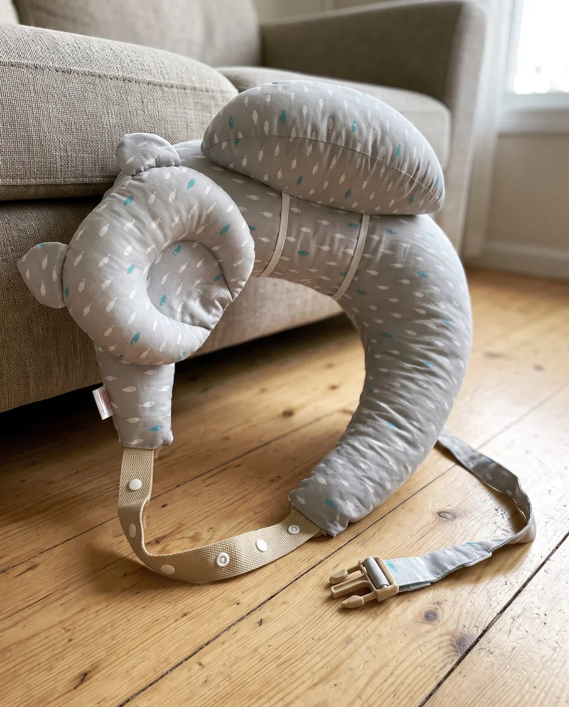 Side view: the raised top cushion sits on the U pillow, held by an elastic band